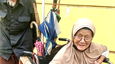 Di Usia Senja, Pak Ismawan Dorong Istri di Kursi Roda Usang Mengais Rezeki di Jalanan Kota Bekasi